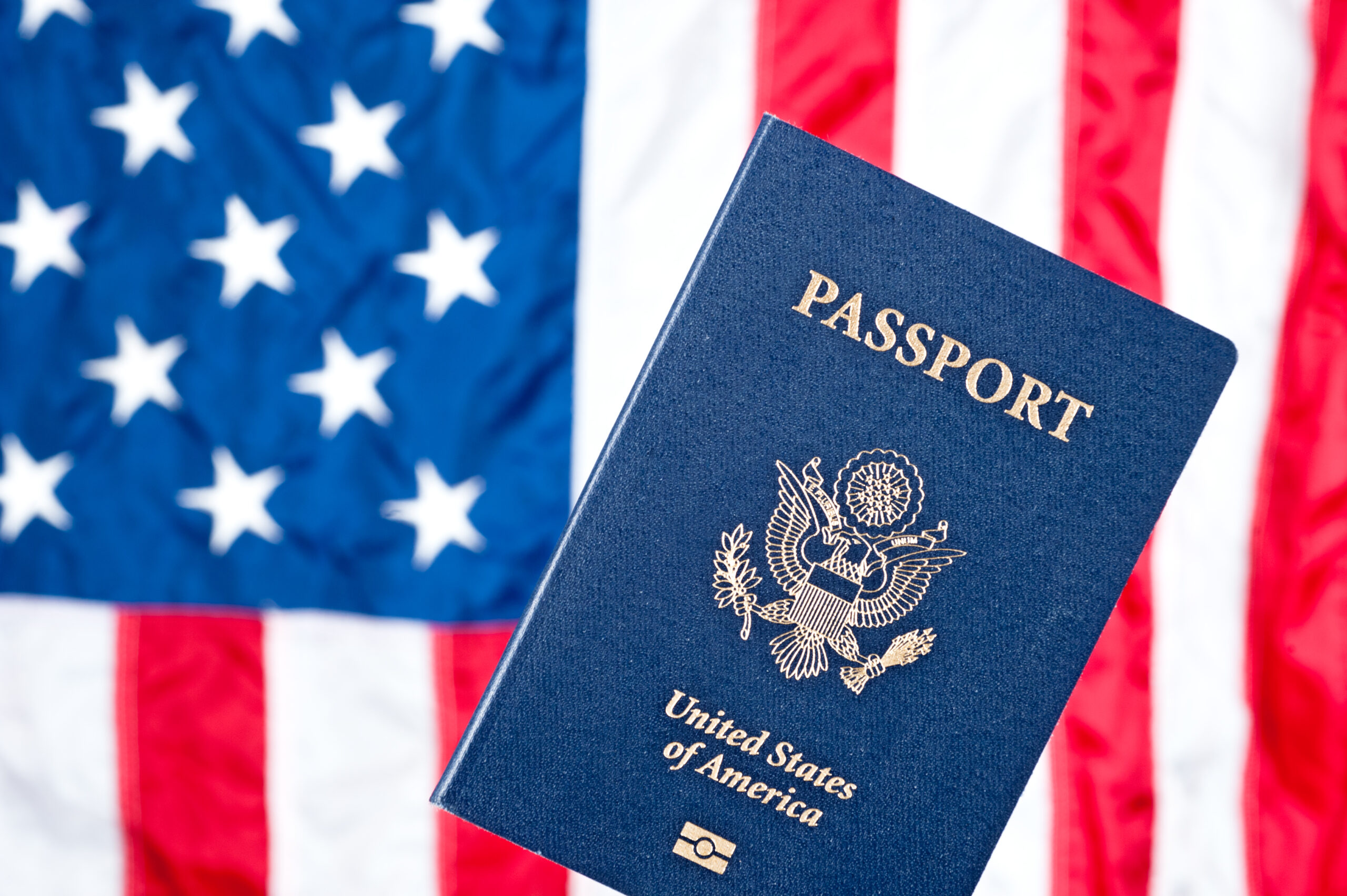 A passport with the American flag in the background.
