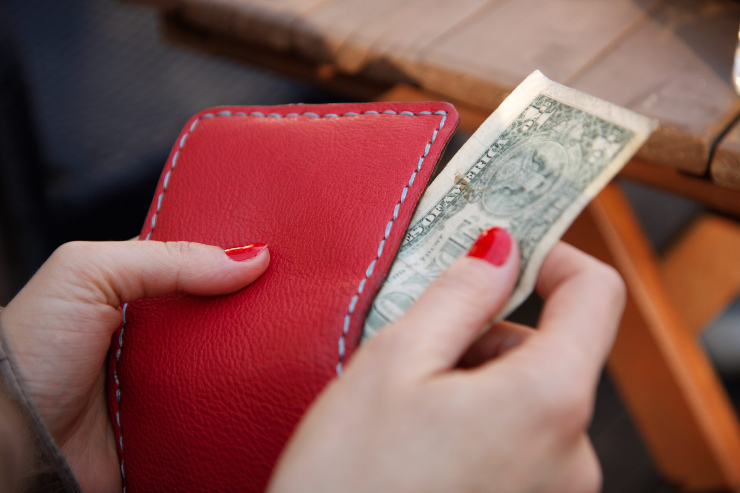 A woman taking a bill out of her wallet