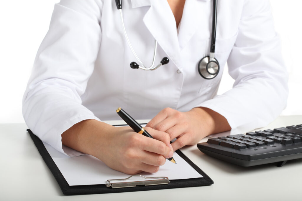 Doctor in a consulting room taking notes.