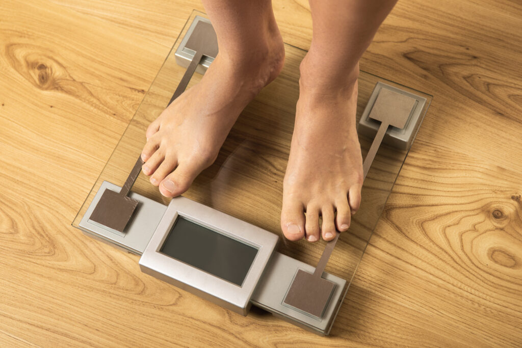 Female feet on the modern weighing scale