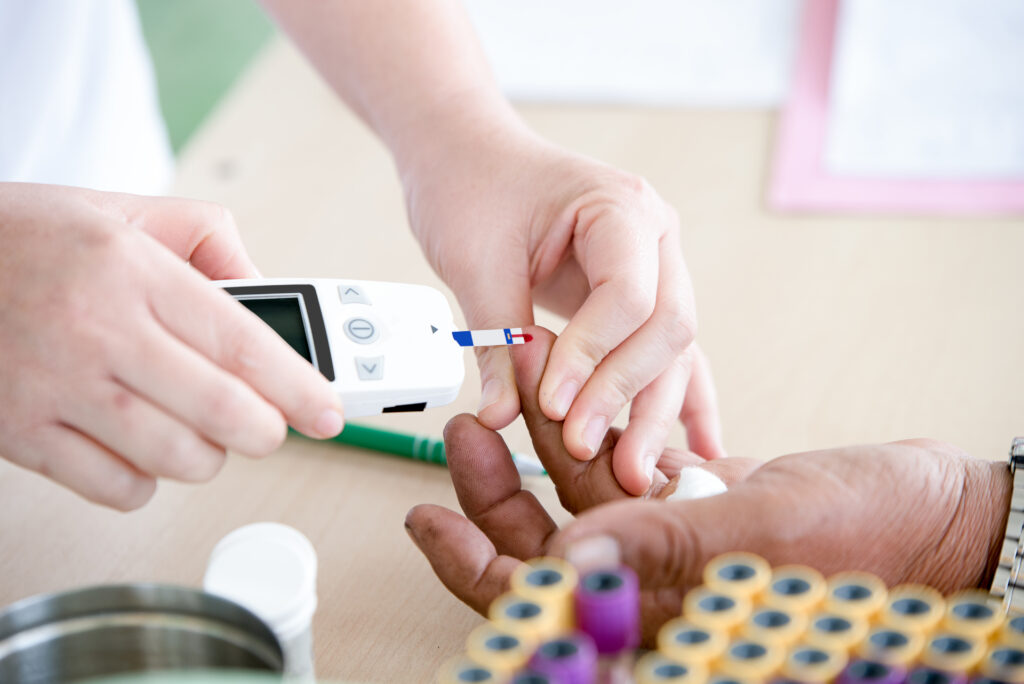 Doctor measuring glucose levels on a patient.